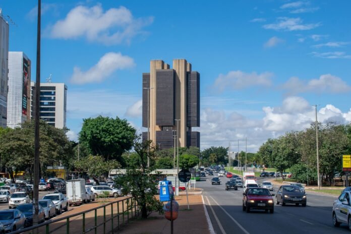 Vista urbana de Brasília com o edifício-sede do Banco Central do Brasil sob céu ao entardecer