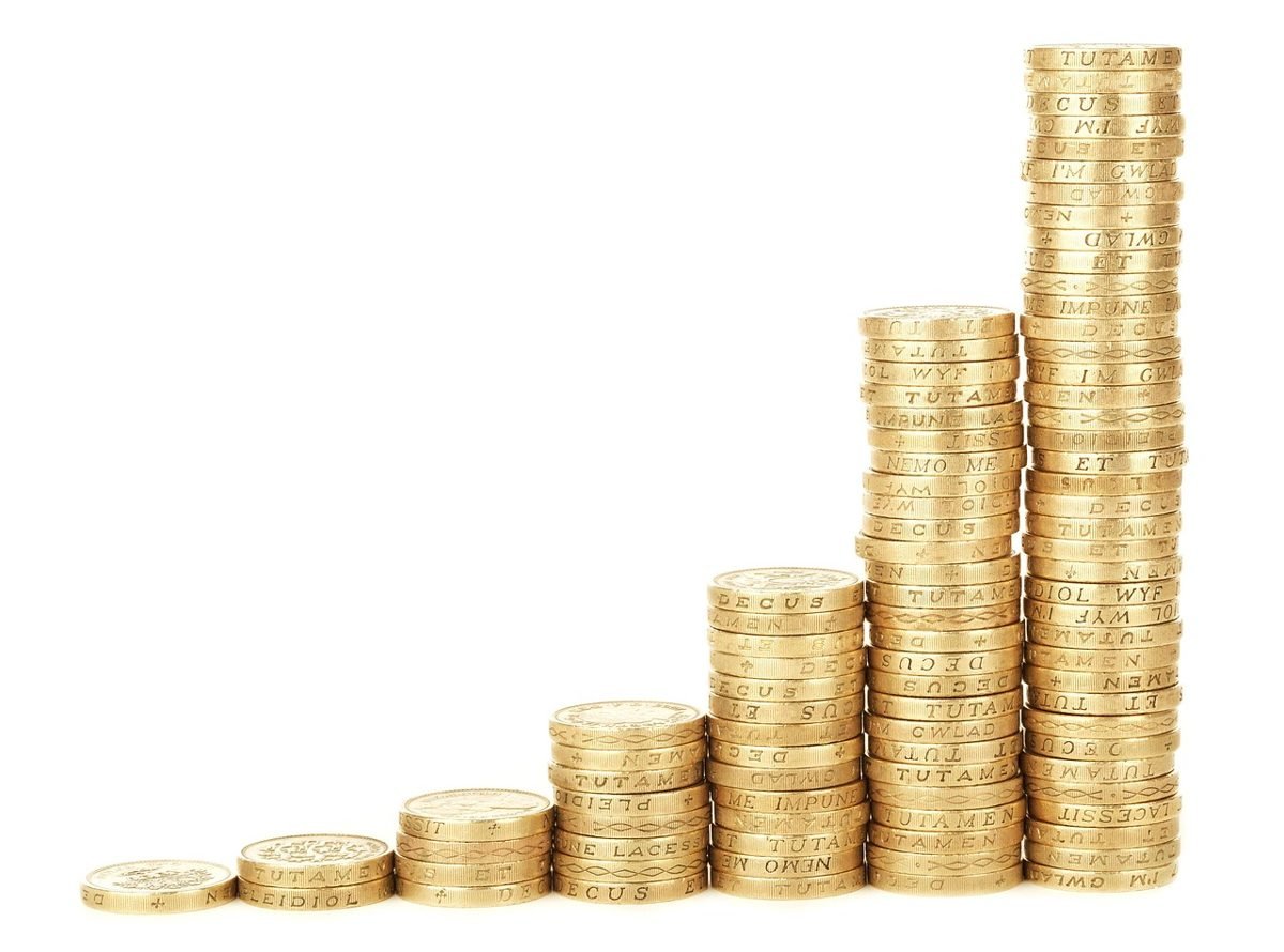Pilhas de moedas em ordem crescente formando um gráfico de barras, simbolizando o crescimento da poupança de longo prazo