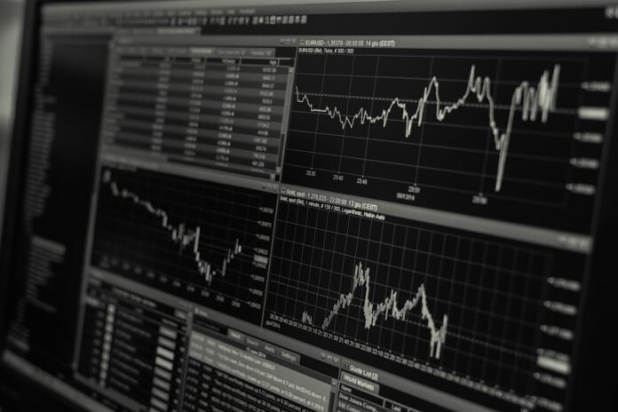 Tela de monitor exibindo gráficos de mercado financeiro e cotações em ambiente de trading, ilustração de análise de juros e mercado