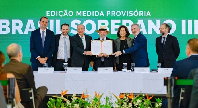 Presidente Lula, usando chapéu, ao lado de ministros durante cerimônia de assinatura da Medida Provisória do Brasil Soberano III, no Palácio do Planalto