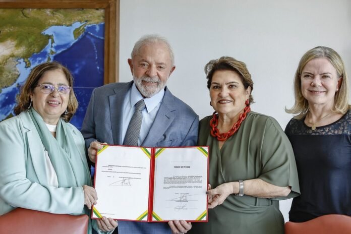 Presidente Luiz Inácio Lula da Silva sorridente ao lado de autoridades durante cerimônia oficial no Palácio do Planalto