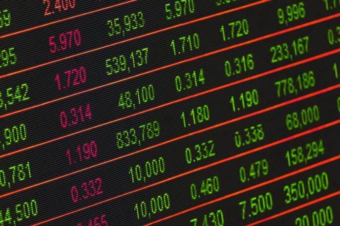 Painel eletrônico de cotações exibindo números em verde, simbolizando alta do mercado financeiro